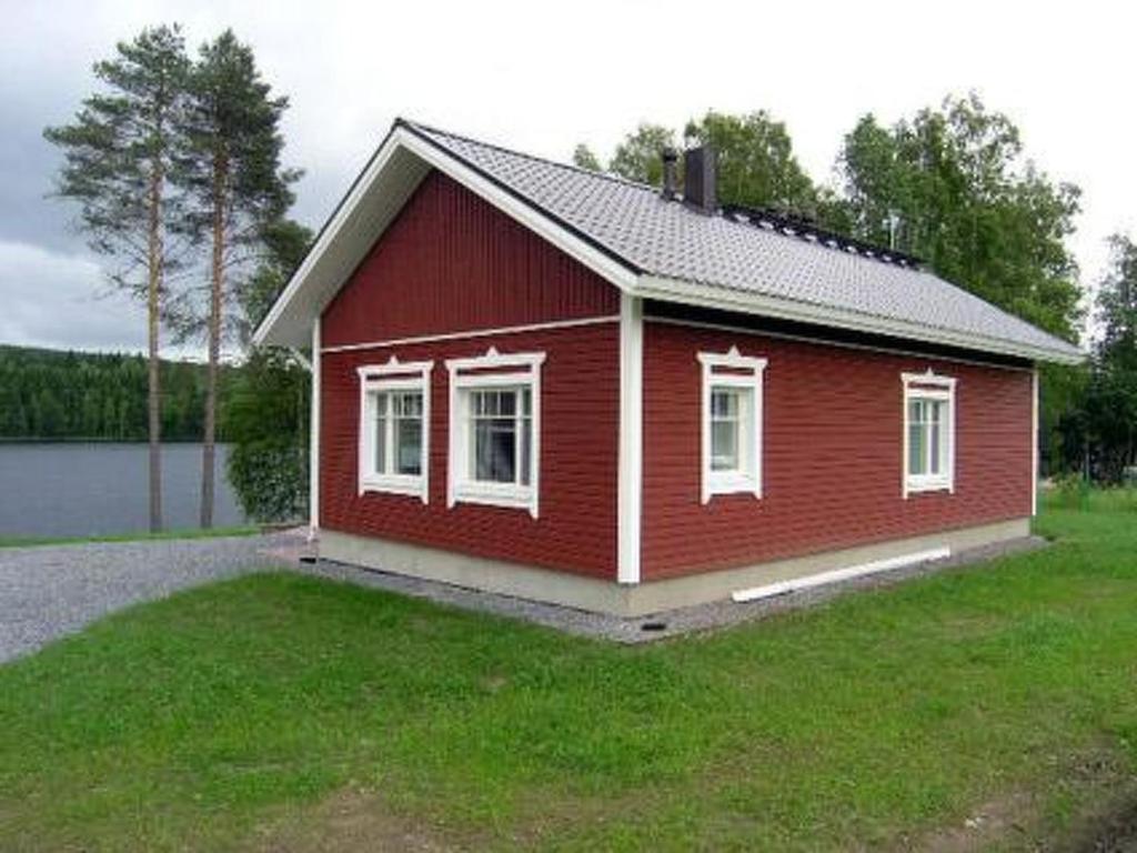 een klein rood huis bovenop een grasveld bij Holiday Home Talvikki by Interhome in Kurkimaki