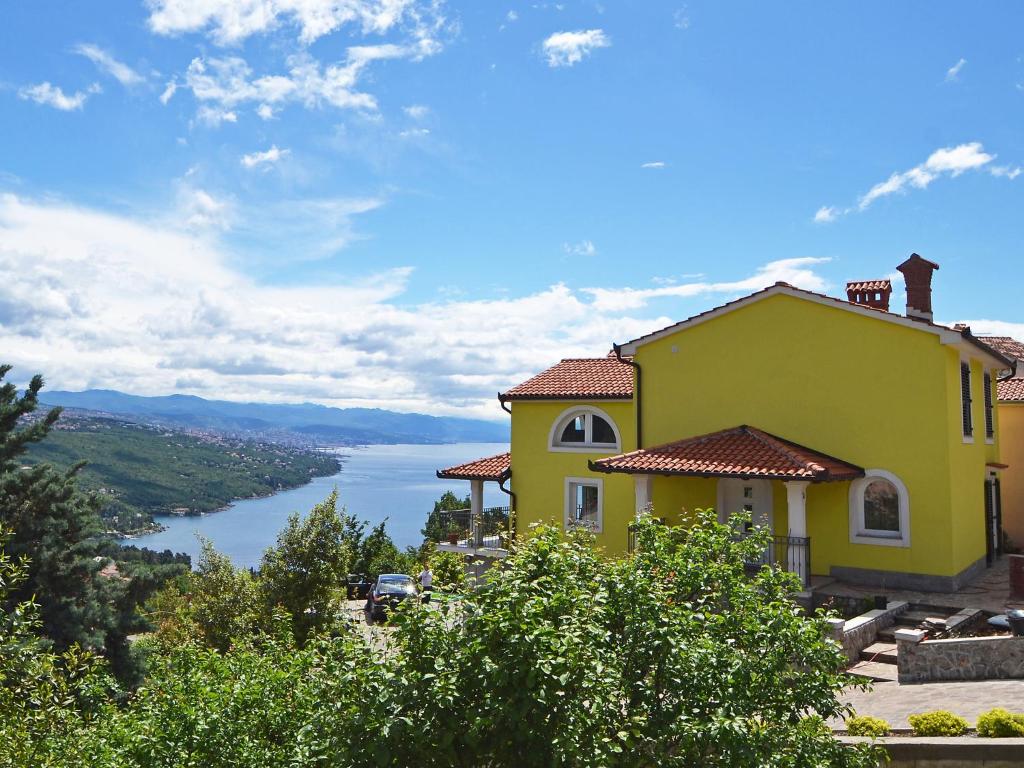 a yellow house with a view of a lake at Villa Izzi Opatija in Opatija