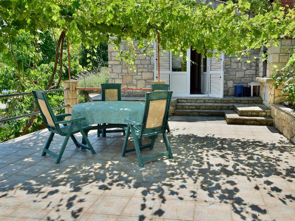 a green table and chairs on a patio at Holiday Home Ratimir by Interhome in Rogač