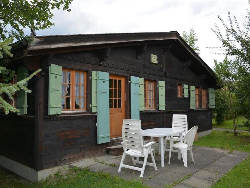 ein kleines Haus mit einem Tisch und Stühlen davor in der Unterkunft Apartment Ismene- Chalet by Interhome in Gstaad