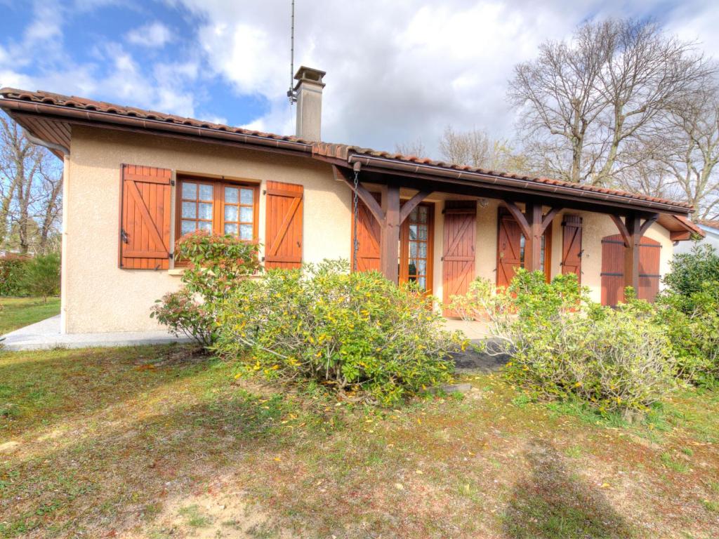 uma casa com portas cor-de-laranja ao lado dela em Holiday Home Les Vignes Océanes by Interhome em Capbreton
