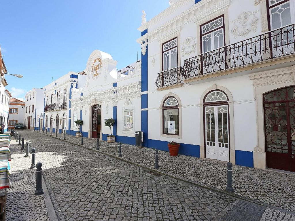 una calle adoquinada con edificios blancos y azules en Studio studio Ericeira by Interhome, en Ericeira