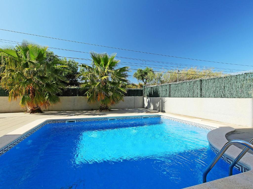 a large blue swimming pool next to a fence at Apartment Can Pavet by Interhome in Vilafortuny