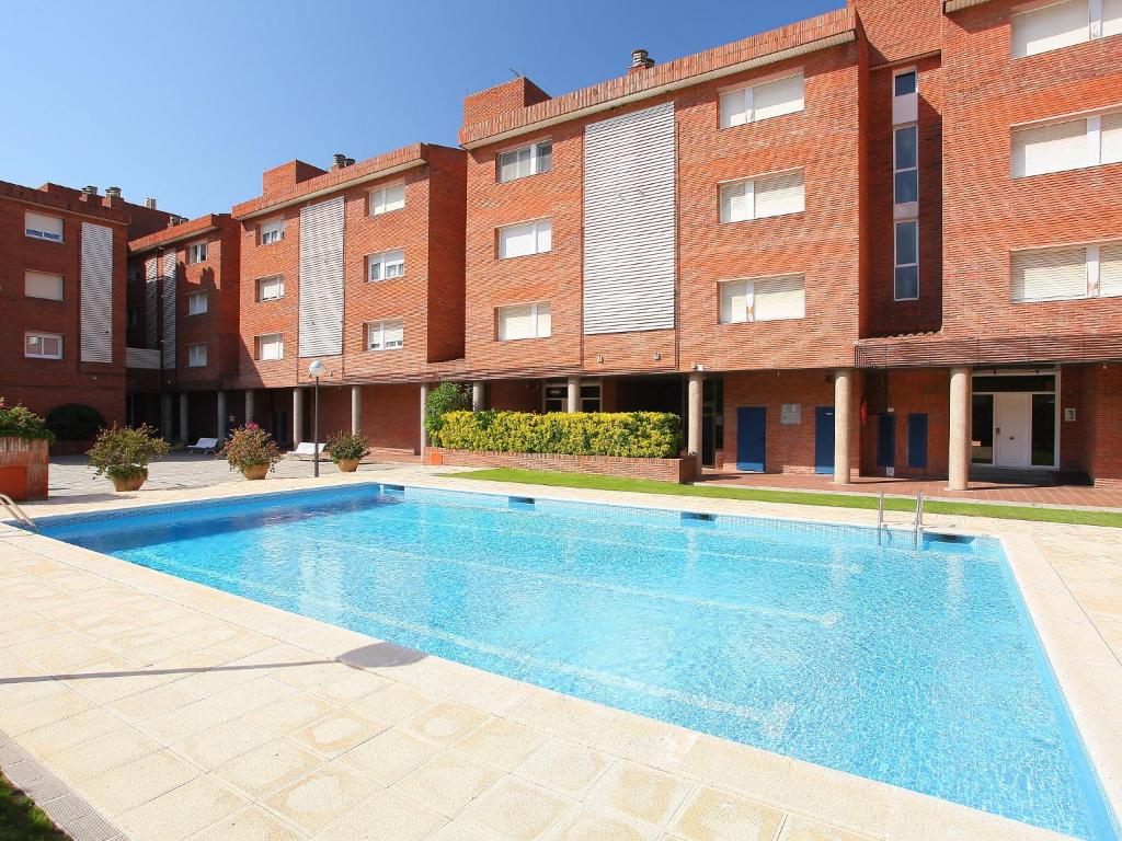 a swimming pool in front of a building at Apartment Rambla de Tossa by Interhome in Tossa de Mar