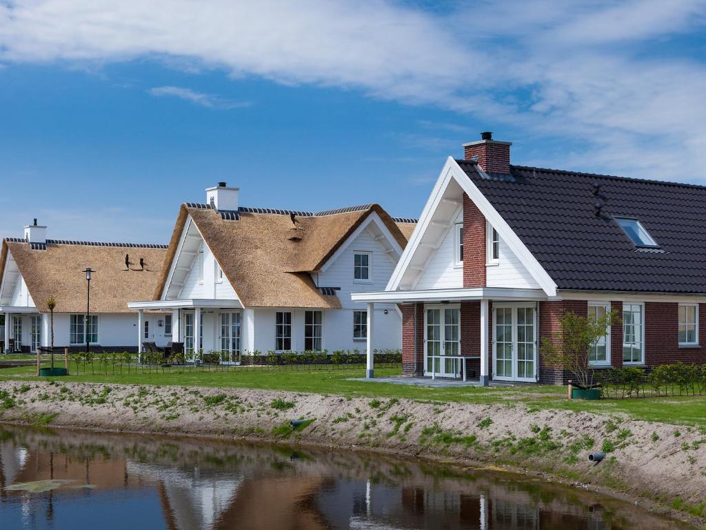 uma fila de casas ao lado de uma massa de água em Holiday Home de Witte Raaf by Interhome em Noordwijk