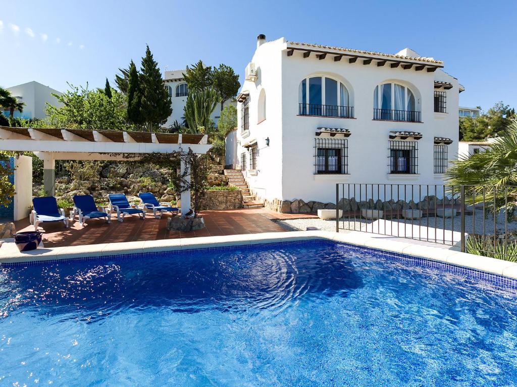 a swimming pool in front of a house at Villa Flores by Interhome in Monte Pego