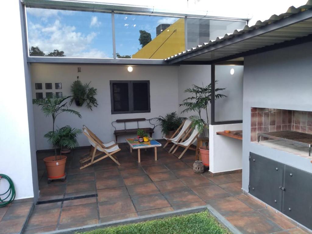 un patio con sillas, mesa y chimenea en Casa confortable en Córdoba