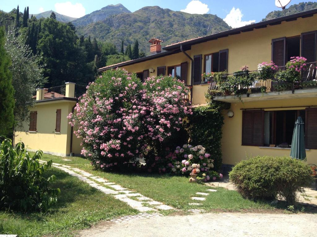 uma casa com flores ao lado dela em Casa Pini em Griante Cadenabbia