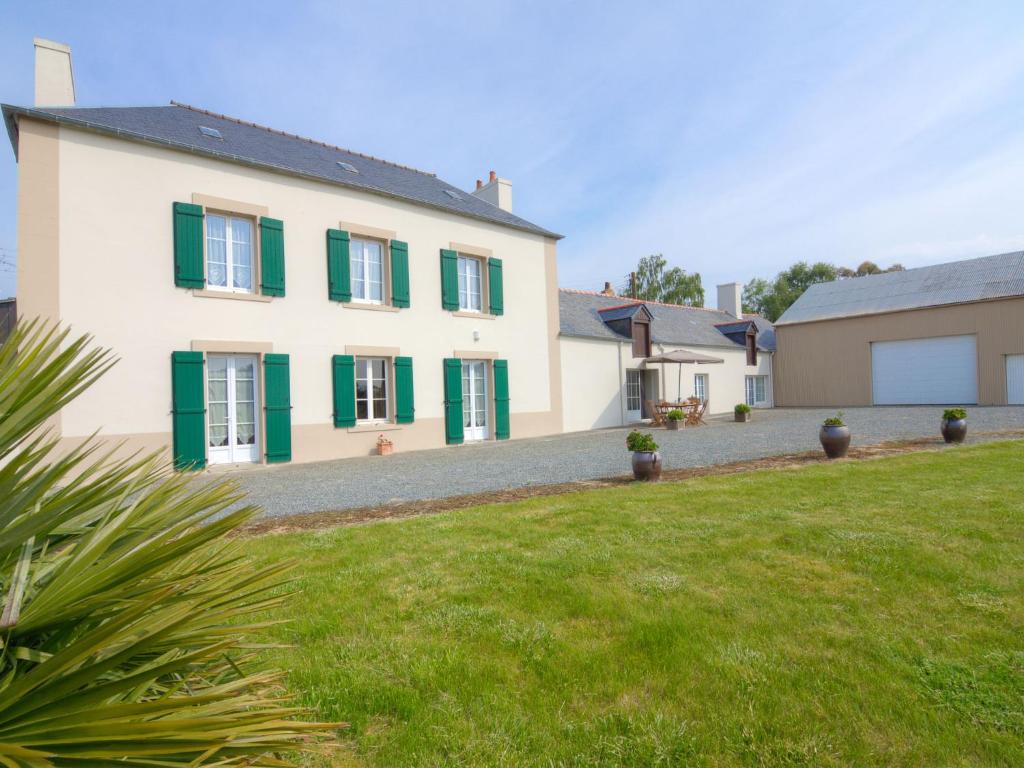 a large white house with green shutters and a yard at Holiday Home La Hulotais by Interhome in Saint Malo