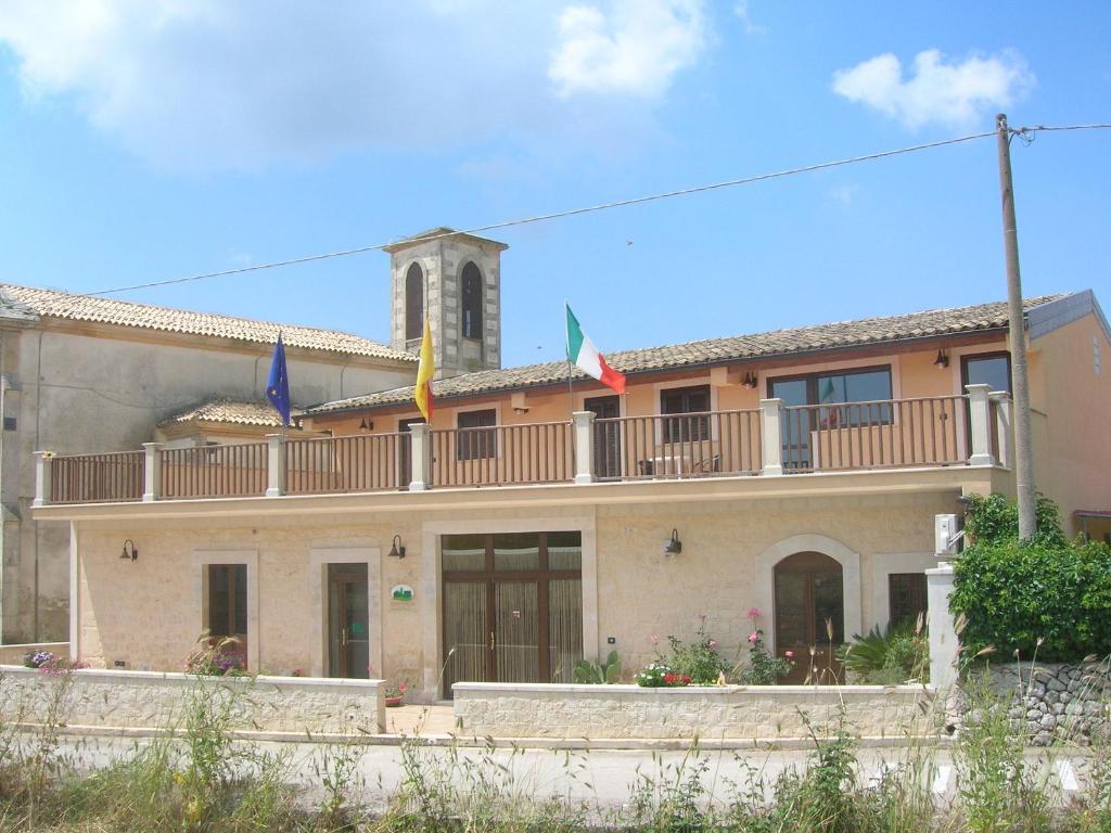 ein Gebäude mit drei Flaggen auf dem Balkon in der Unterkunft Borgo Rigolizia Vacanze in Rigolizia