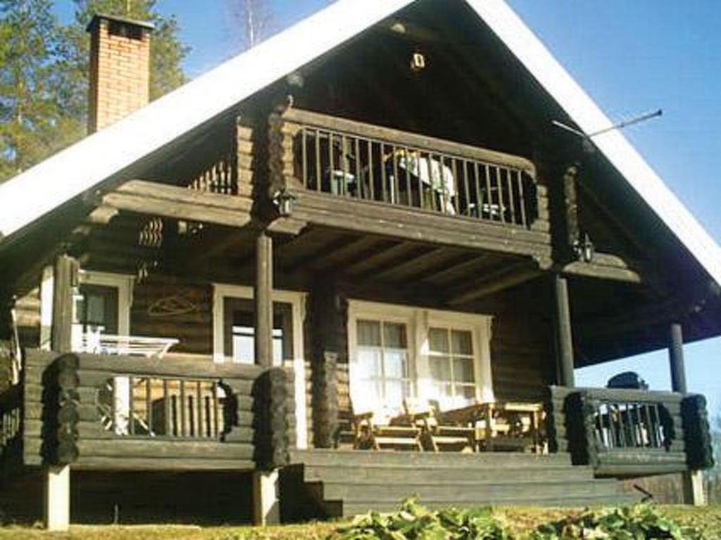 a large wooden house with a porch and a balcony at Holiday Home 6144 by Interhome in Jäniskylä