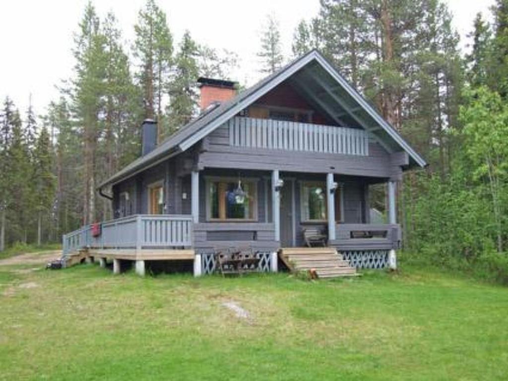 a gray house with a porch on a field at Holiday Home Kumpulahti by Interhome in Käylä