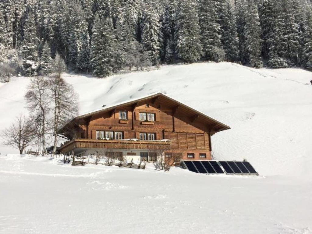 a log cabin in the snow with solar panels at Apartment Abelied by Interhome in Adelboden