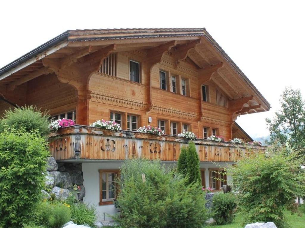 ein Holzhaus mit Balkon darüber in der Unterkunft Apartment Rawilstrasse 33 by Interhome in Lenk im Simmental