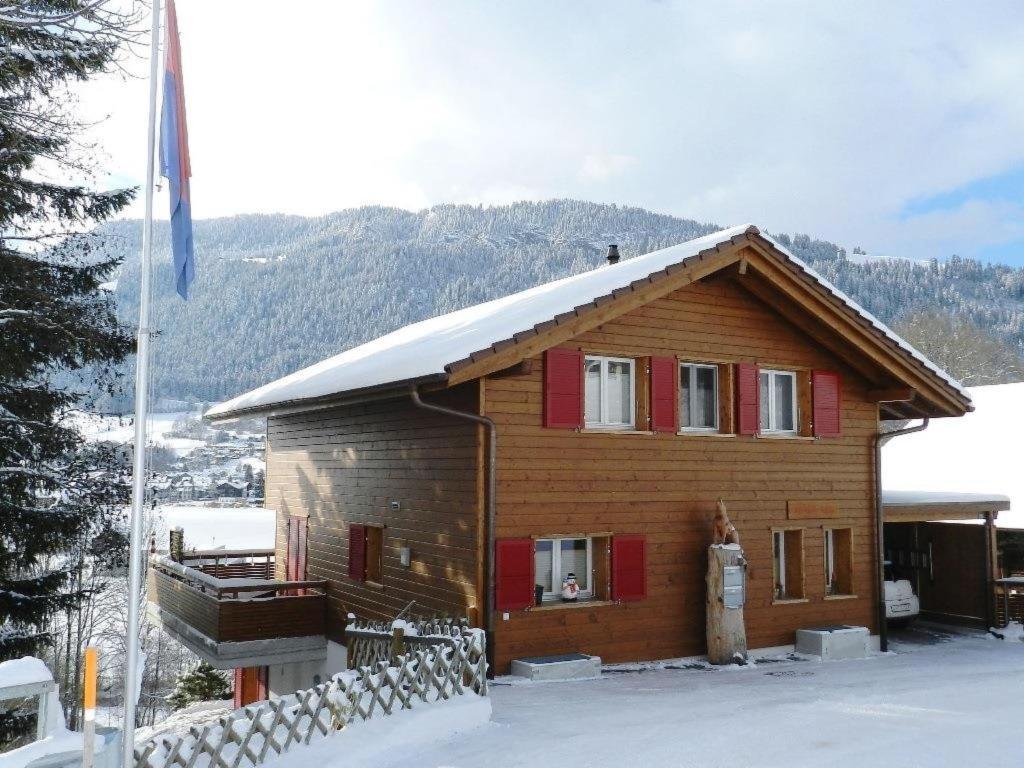 een houten huis met sneeuw op het dak bij Apartment Schön-Egg by Interhome in Zweisimmen
