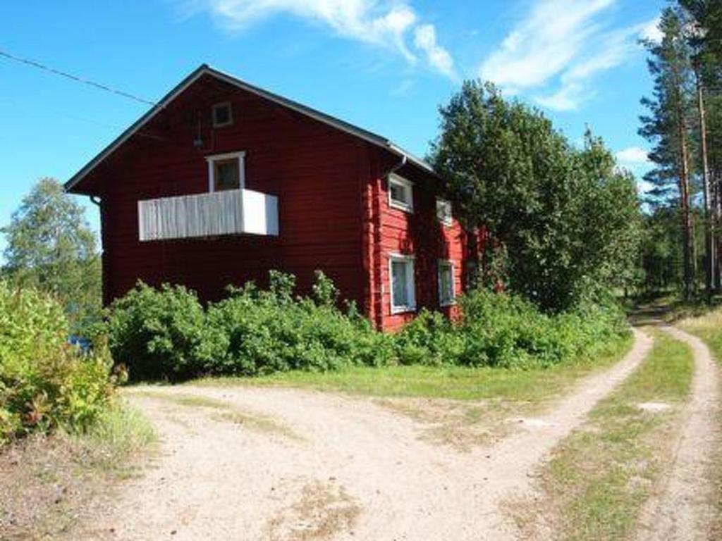 un granero rojo sentado al lado de un camino de tierra en Holiday Home Raanumaja iii by Interhome, en Lampsijärvi