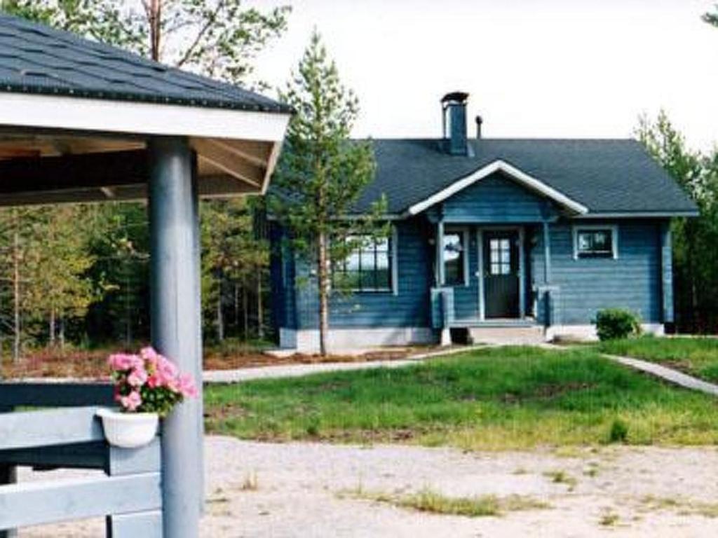 a blue house with a flower pot on a porch at Holiday Home Mäntyaho by Interhome in Karvonen