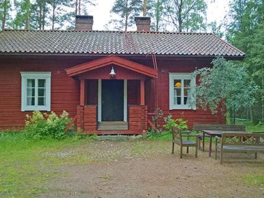 une maison rouge avec une table et un banc devant elle dans l'établissement Holiday Home Villa pettu by Interhome, à Siksalo