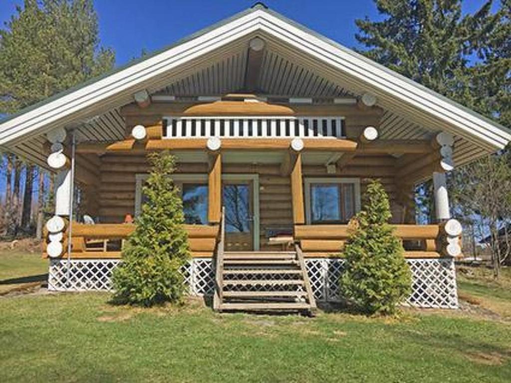 a small log cabin with a porch on a lawn at Holiday Home Suviranta by Interhome in Syvärinpää