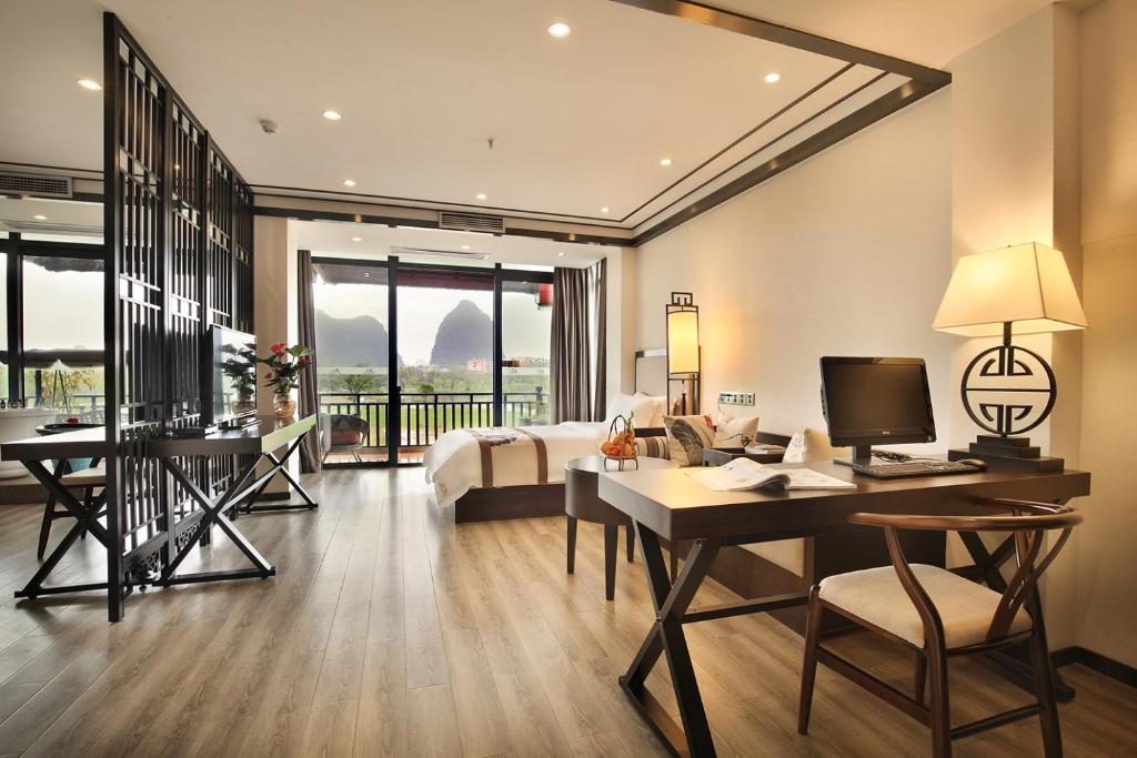una camera d'albergo con letto e scrivania con computer di Peach Blossom Resort Hotel a Guilin