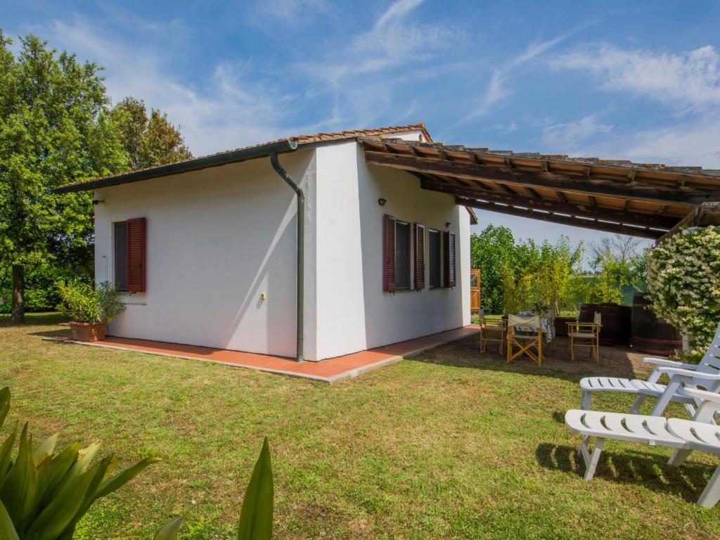 mały biały dom ze stołem i krzesłami w obiekcie Holiday Home Casetta Ponticelli by Interhome w mieście Lavaiano