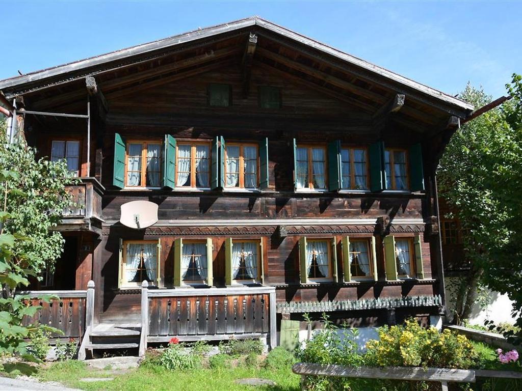 a wooden house with a fence in front of it at Apartment Mittaghorn by Interhome in Gsteig