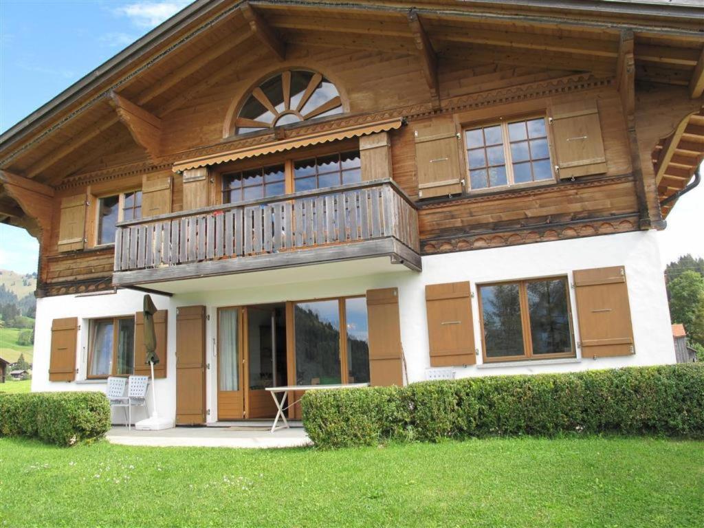 uma grande casa de madeira com uma varanda em Apartment Grüenbüelti by Interhome em Gstaad