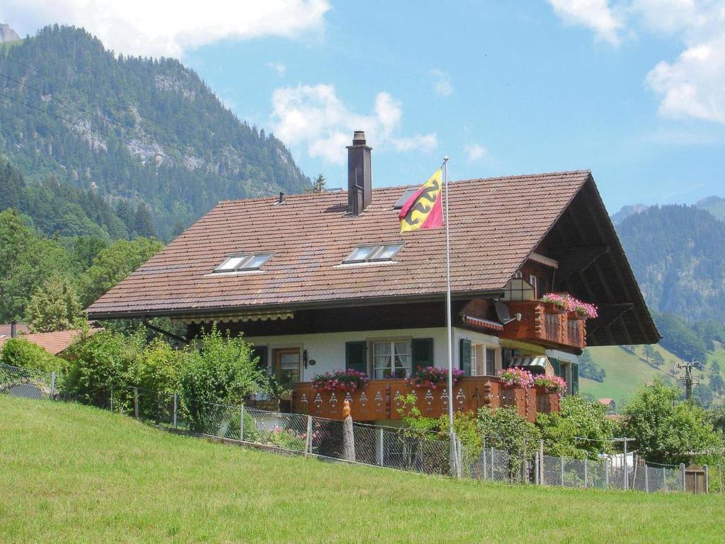 ein Haus auf einem Hügel mit einer Flagge davor in der Unterkunft Apartment Bärgfriede by Interhome in Oberwil