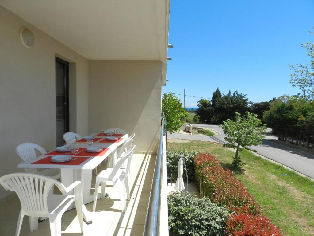 San-GiulianoにあるApartment Lup - Les terrasses d'Alistro by Interhomeの家のバルコニーに白いテーブルと椅子