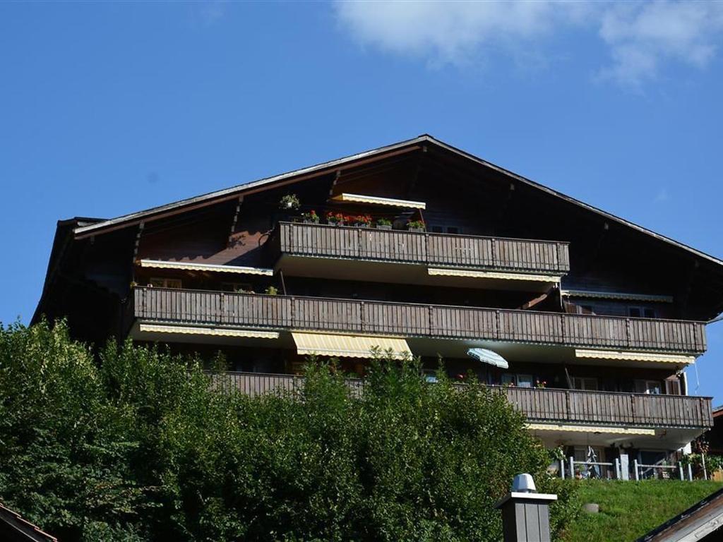 a building with a balcony with people on it at Apartment Hübeli - Arm by Interhome in Zweisimmen