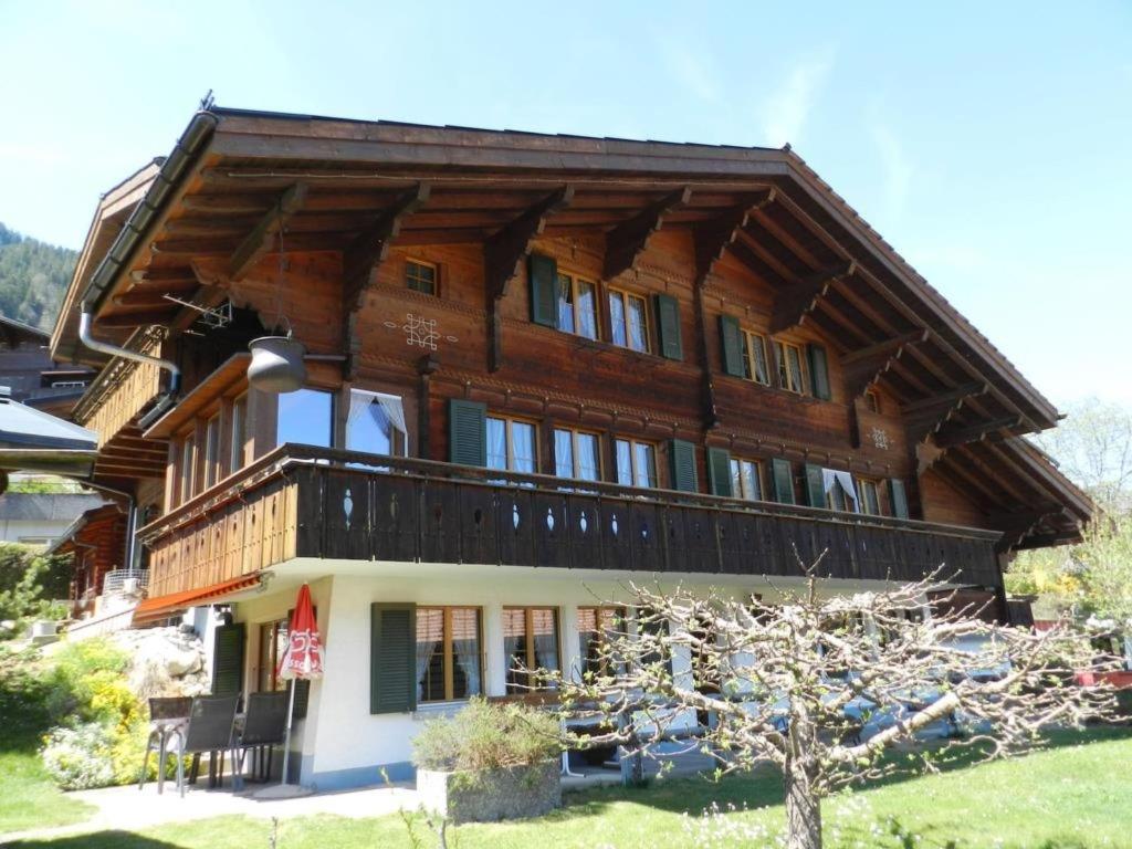 a large wooden house with a gambrel roof at Apartment Bolgen by Interhome in Zweisimmen
