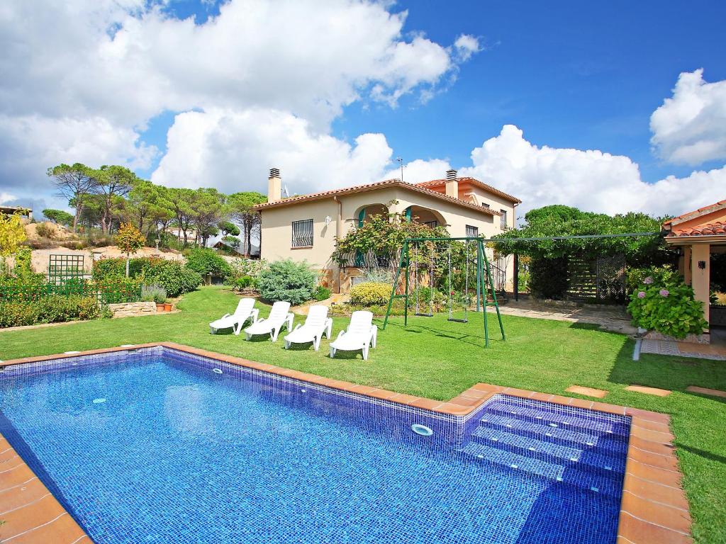 uma casa com uma piscina com cadeiras e um baloiço em Holiday Home Marina by Interhome em Vidreres