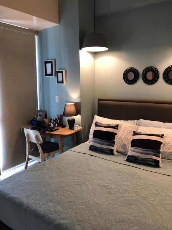 a bedroom with a bed and a desk and a table at Modern and Cozy Studio near Airport Terminal 3 in Manila