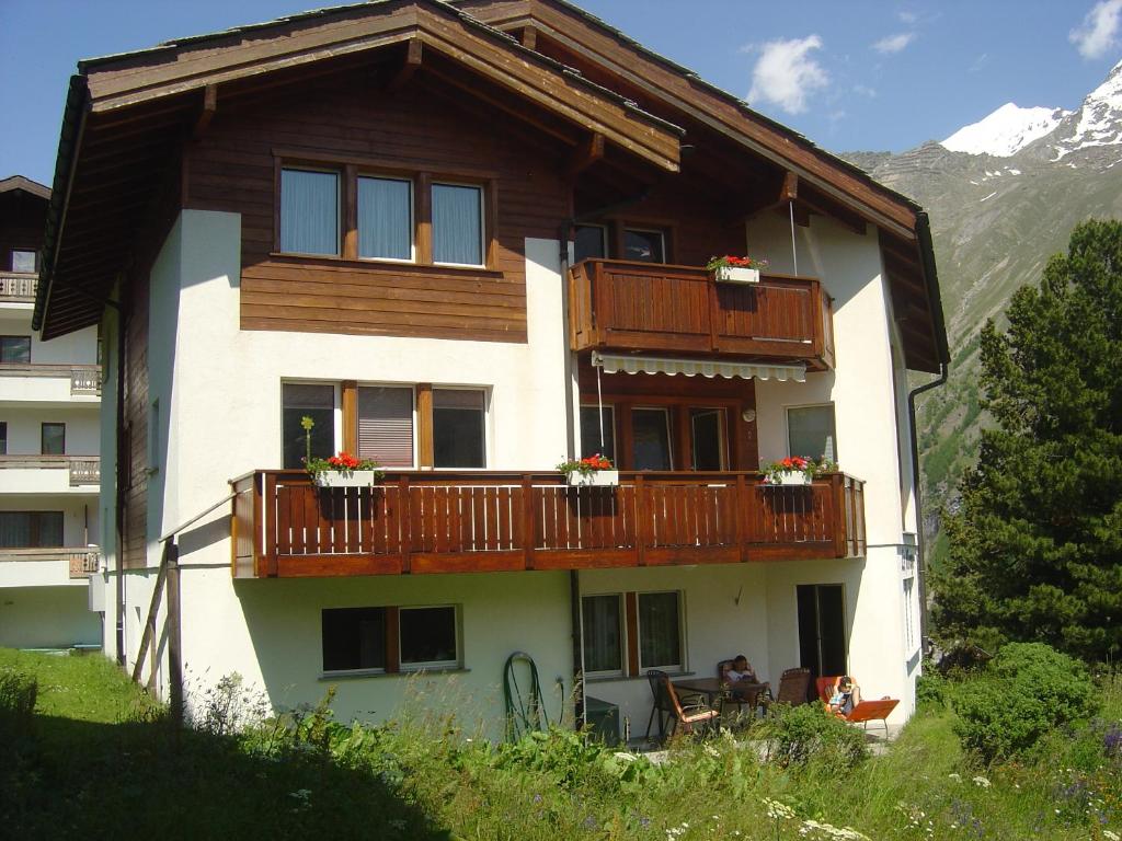 a house with a balcony with flowers on it at Haus Le Mirage in Saas-Fee