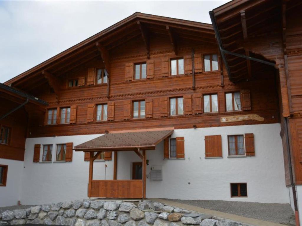 a large wooden building with a wooden roof at Apartment Mireille Nr- 6 by Interhome in Gstaad