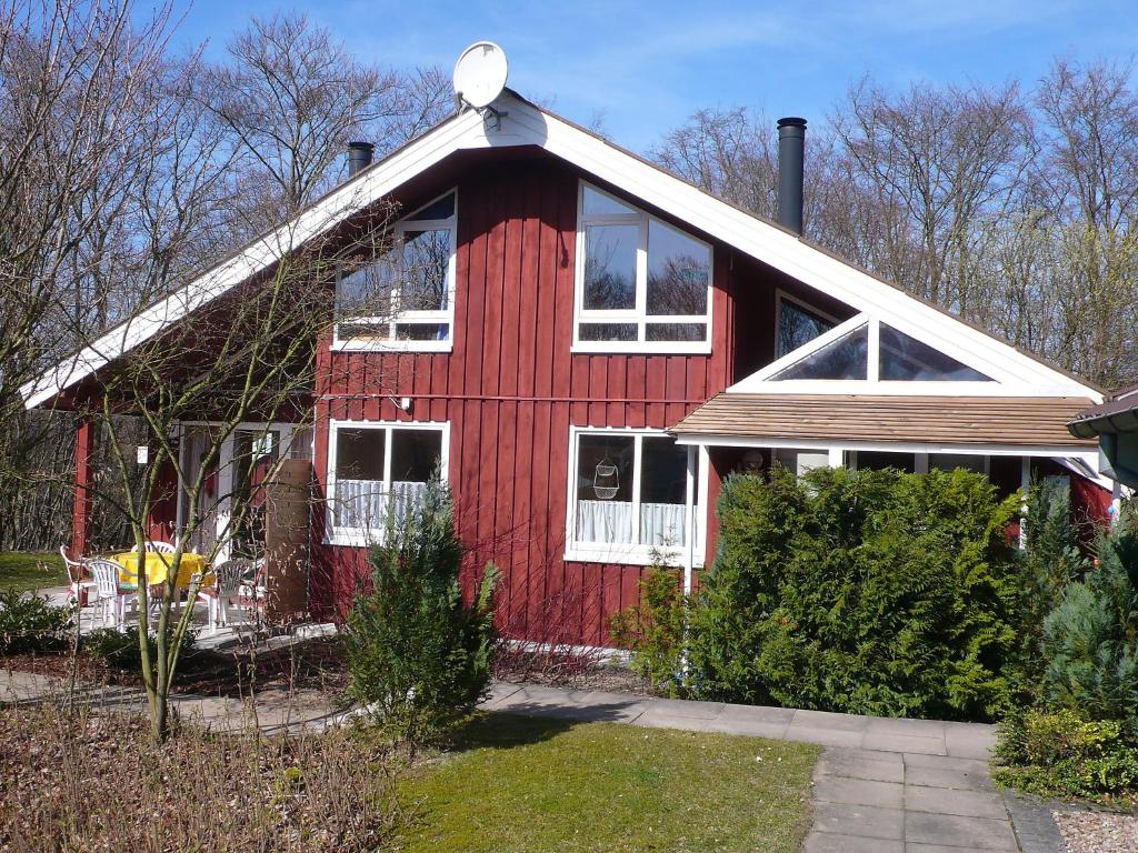 ein rotes Haus mit weißen Fenstern und einem roten in der Unterkunft Holiday Home Ferienpark Extertal-2 by Interhome in Bremke