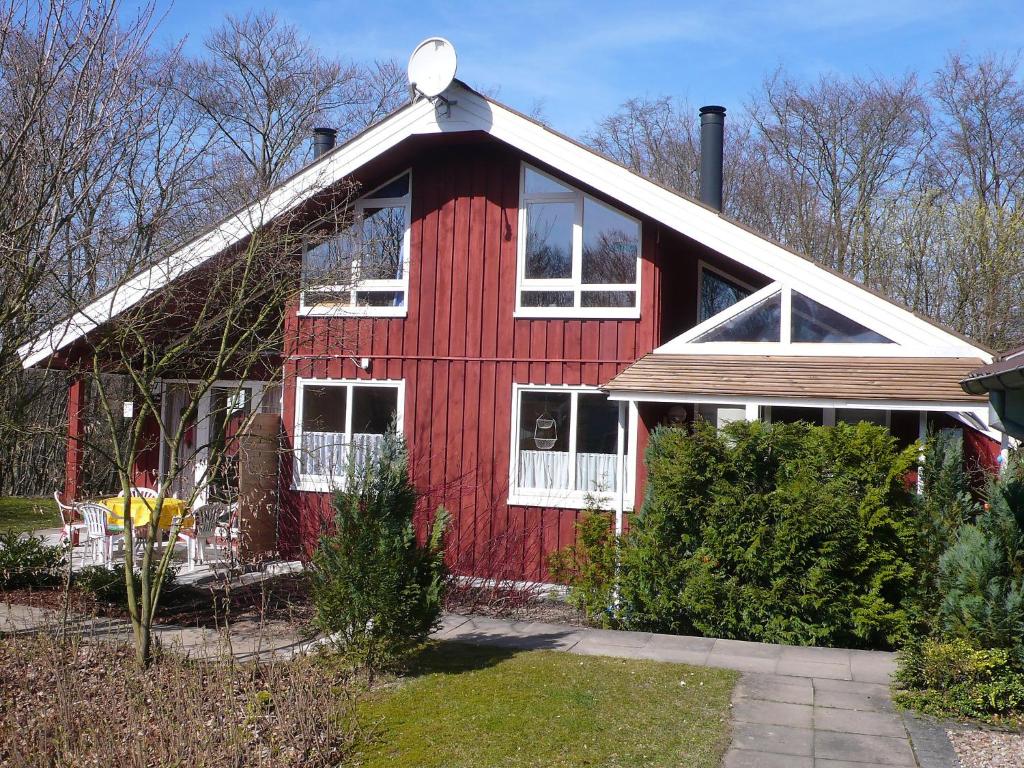 a red house with white windows and a red at Holiday Home Ferienpark Extertal-2 by Interhome in Bremke