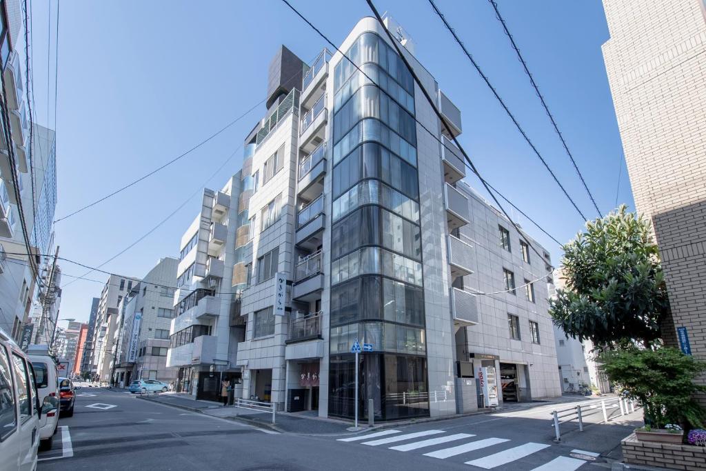Kakigara Ryokan في طوكيو: مبنى زجاجي طويل على شارع المدينة