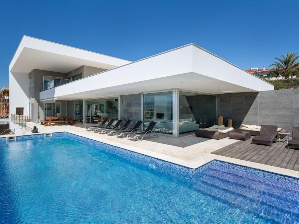 a house with a swimming pool in front of it at Villa Vogue by Interhome in Ferragudo