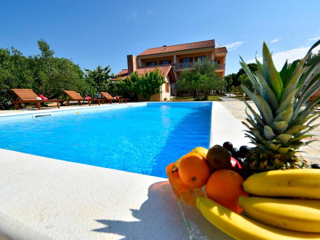 a bowl of fruit sitting next to a swimming pool at Apartment Jasminka-1 by Interhome in Drage