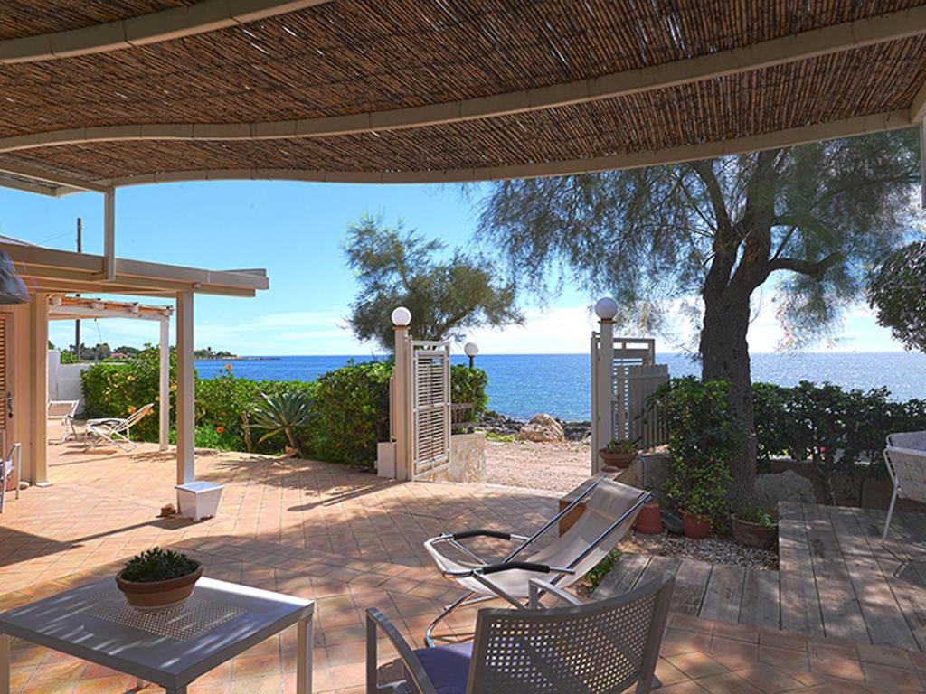 Villa TargiaにあるVilla Marlò by Interhomeの海を望むパティオ(テーブル、椅子付)