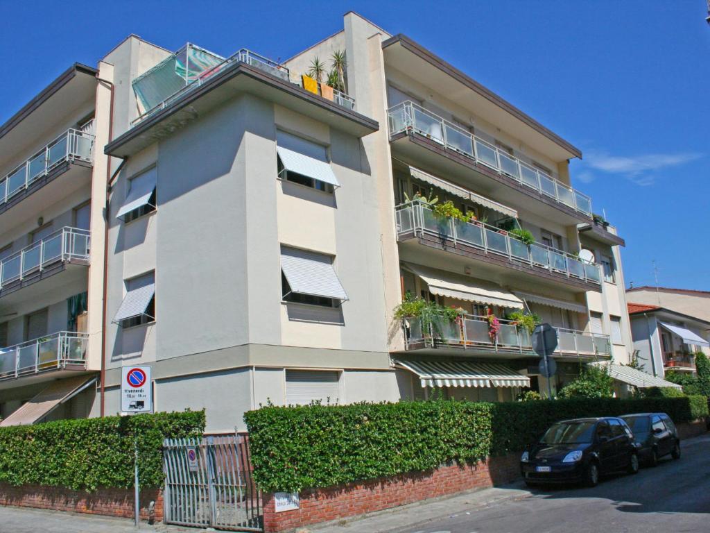 ヴィアレッジョにあるApartment Appartamento Luporini by Interhomeの車が目の前に停まったアパートメントビル