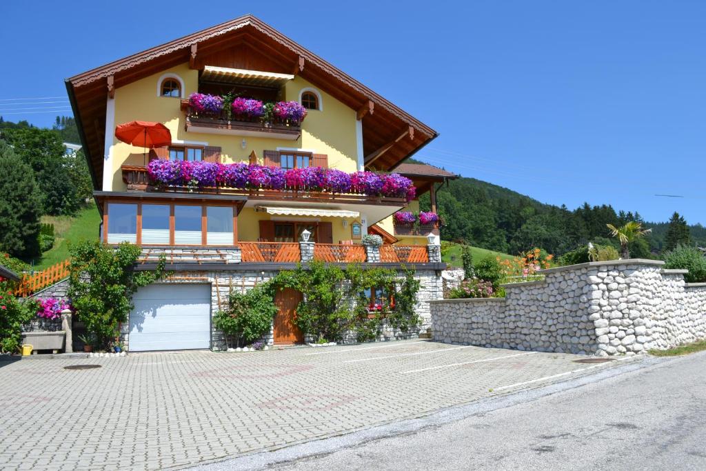 una casa con cajas de flores a un lado. en Gästehaus Sonnenhang, en Mondsee