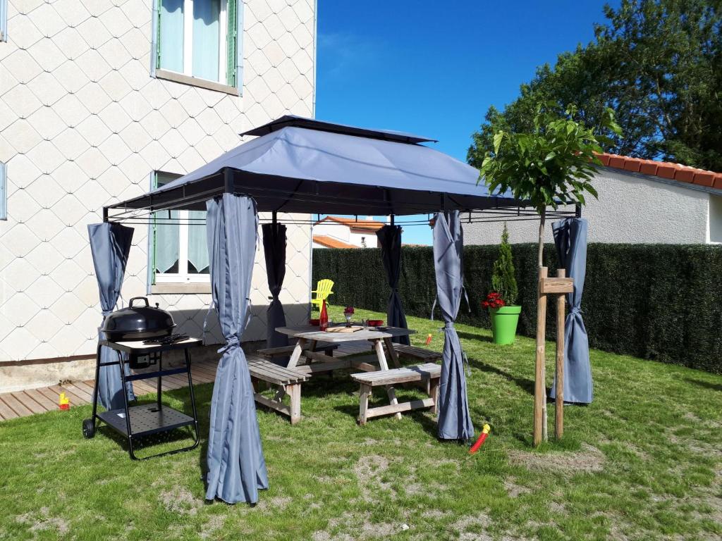 a gazebo with a picnic table and a grill at Holiday Home Maison Les Oies by Interhome in Blot-lʼÉglise