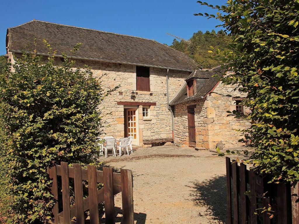 ein altes Steingebäude mit zwei Stühlen davor in der Unterkunft Holiday Home La Colinoise by Interhome in Coly