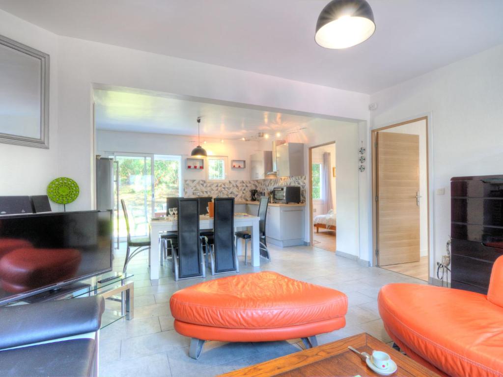 a living room with an orange chair and a table at Holiday Home De la Plage by Interhome in Labenne