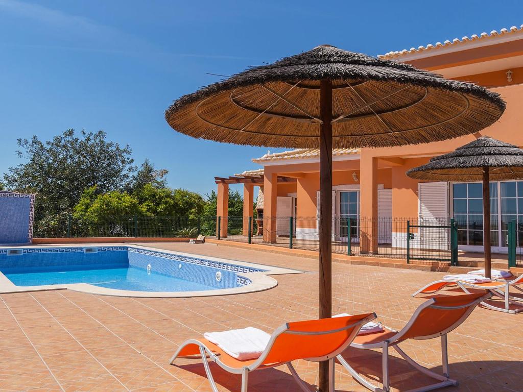 un grupo de sillas y sombrillas junto a una piscina en Villa Casa da Horta by Interhome, en Estevais