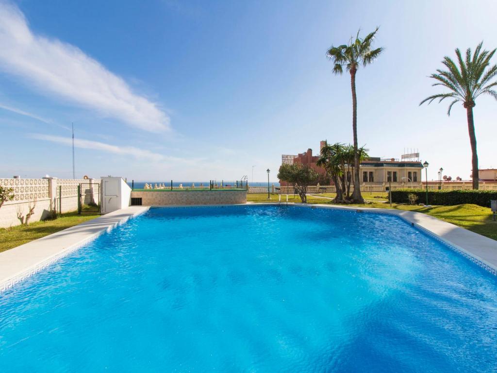 una grande piscina blu con palme di Apartment Apartamento Las Coronas by Interhome a Torremolinos