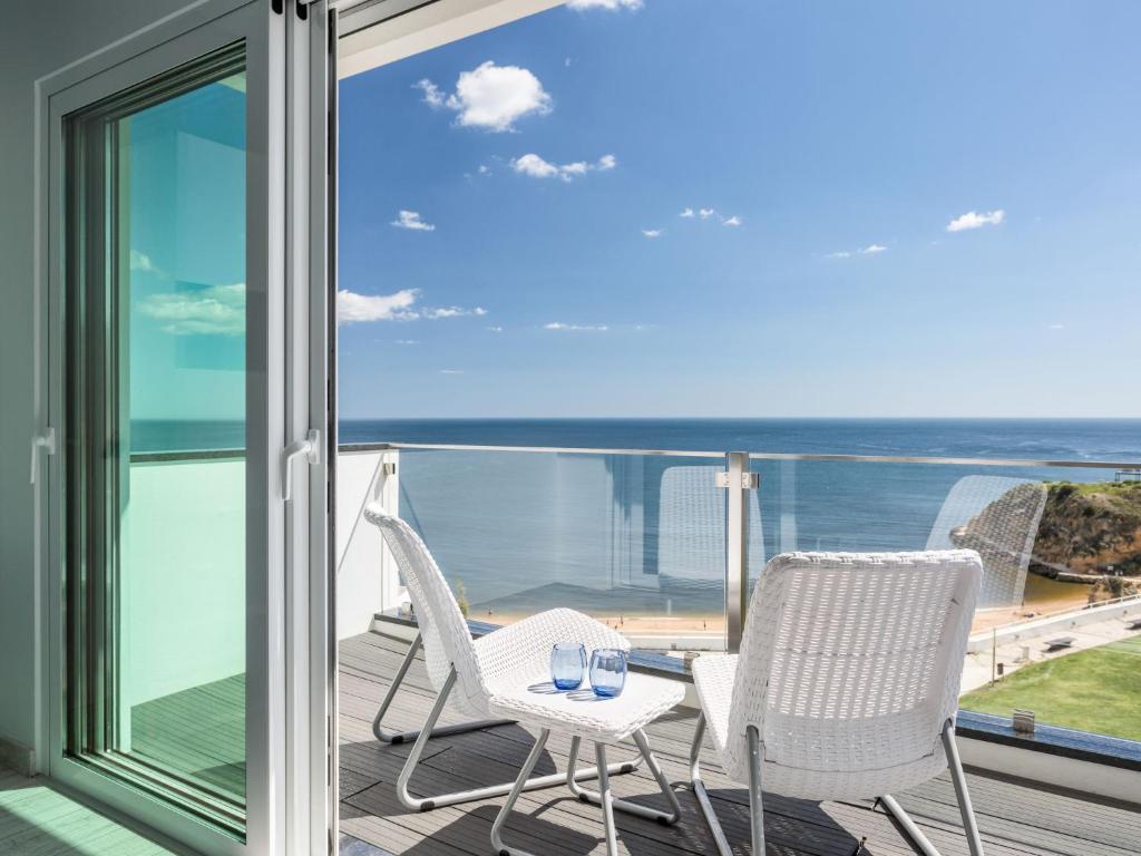 un balcón con 2 sillas y una mesa con gafas. en Studio Dream View 50m from the beach by Interhome, en Albufeira