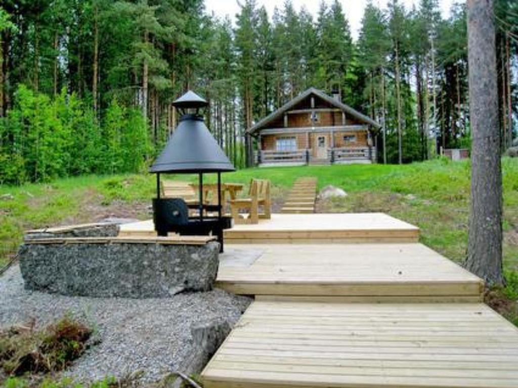 a log cabin with a table and a chair in front at Holiday Home 6309 by Interhome in Konginkangas